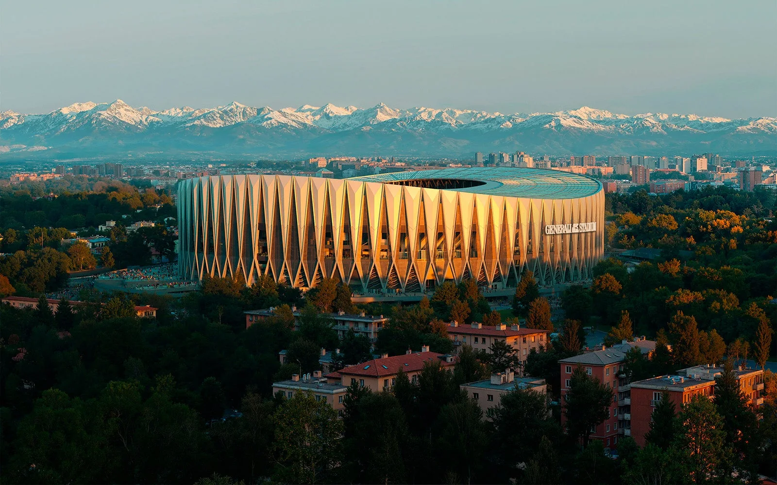 Rendering aereo del Generali Stadium a Milano al tramonto, con le Alpi sullo sfondo